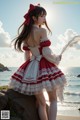 A woman in a red and white dress standing on a rock by the ocean.