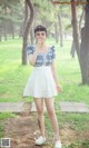 A woman in a white skirt and a blue and white shirt.