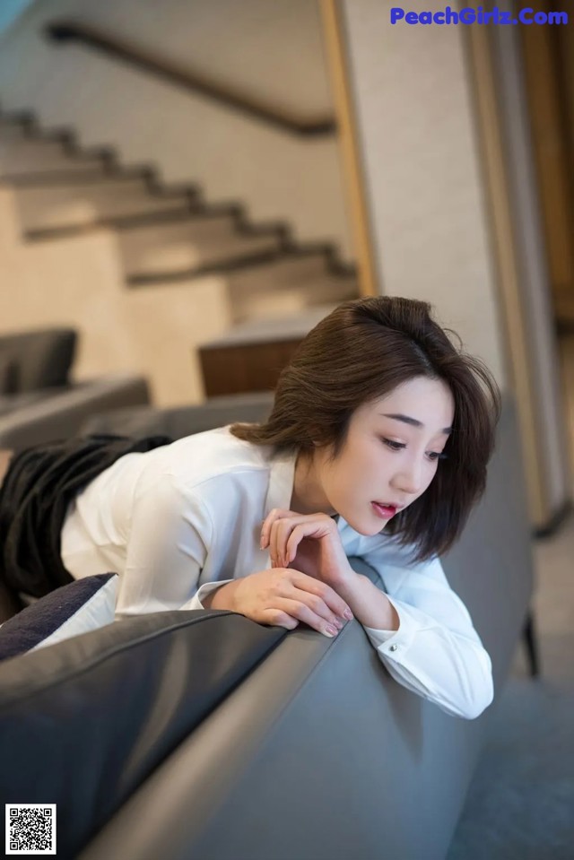 A woman laying on a couch in a room.