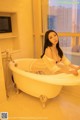 A woman sitting in a bathtub in a bathroom.