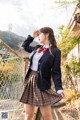 A woman in a school uniform is posing for a picture.