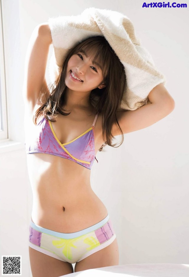 A woman in a bikini with a towel on her head.