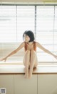 A woman sitting on top of a window sill.