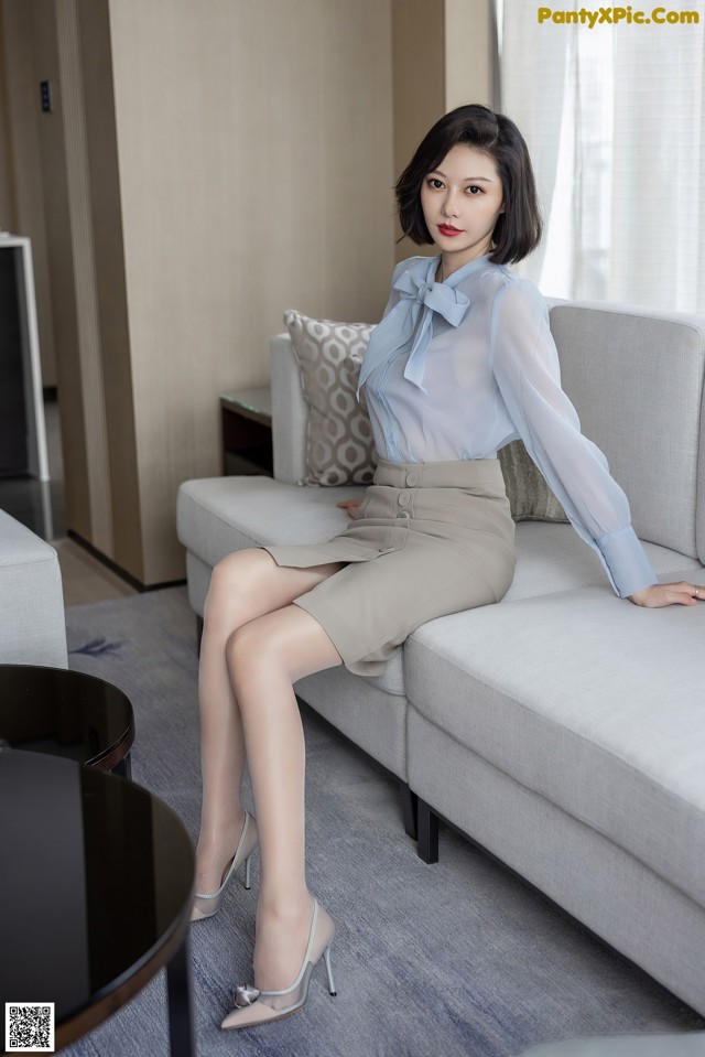 A woman sitting on a couch in a living room.