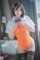 A woman in an orange bodysuit and black stockings posing for a picture.